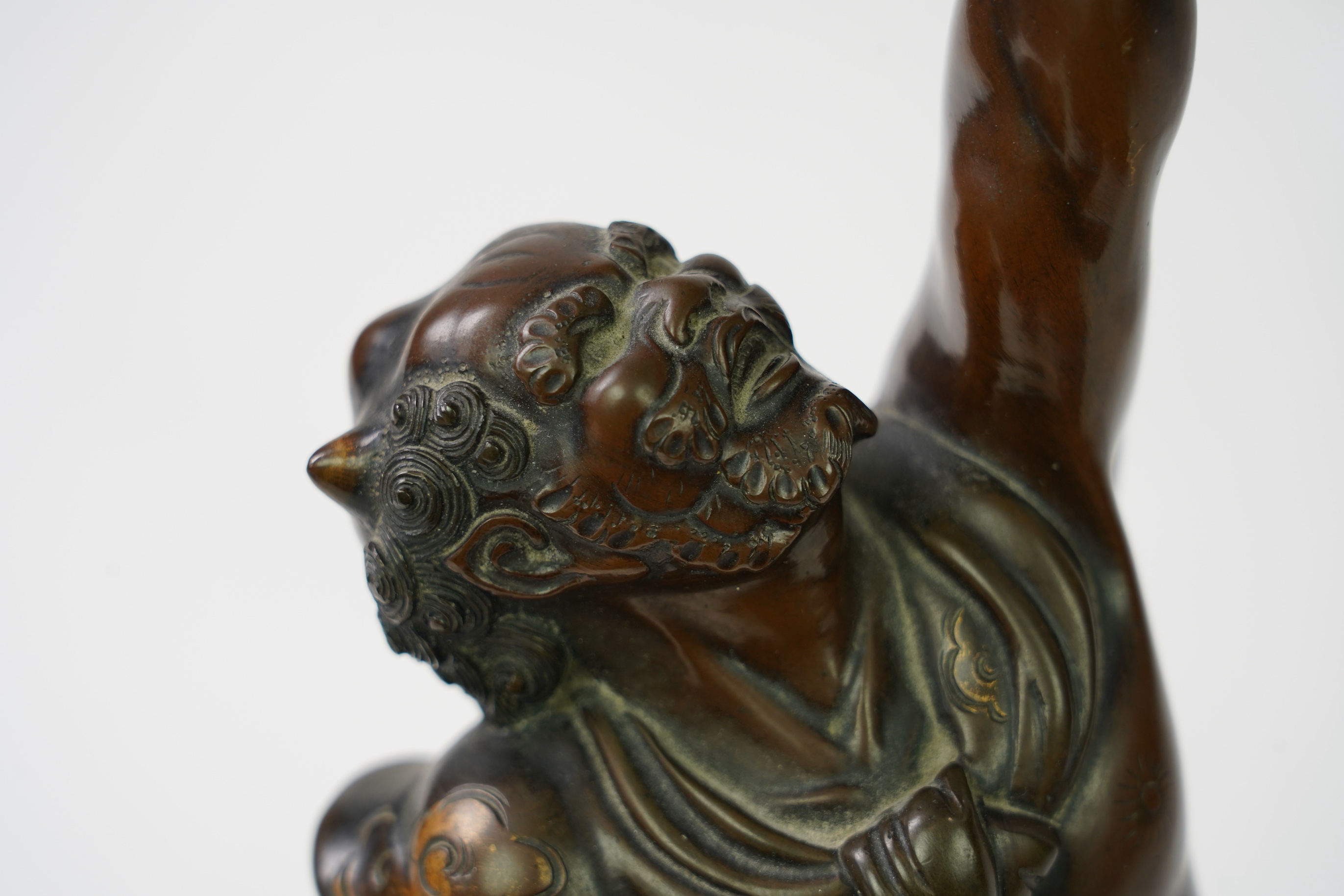 A Japanese bronze figure of an Oni holding a temple bell aloft, Meiji period, in Miyao style